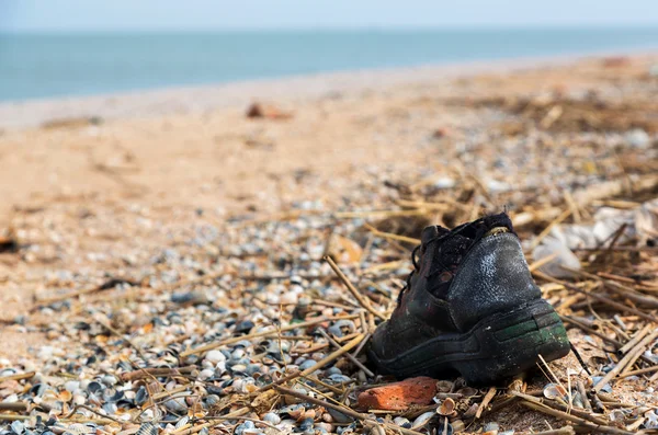 Poluição: sapatos, garagens, plástico e resíduos na praia após tempestades de inverno. Mar de Azov. Dolzhanskaya Cuspo Imagens De Bancos De Imagens Sem Royalties