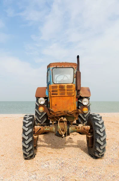 Trator laranja velho na praia arenosa. Mar de Azov. Dolzhanskaya Cuspo Imagens De Bancos De Imagens Sem Royalties