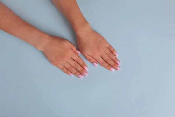 Stylische trendige weibliche Maniküre. Hände einer schönen Frau auf blauem Hintergrund. Flache Verlegestile. — Stockfoto