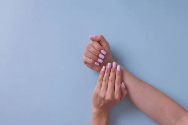Primer plano de las manos de una joven con manicura rosa. Imágenes De Stock Sin Royalties Gratis