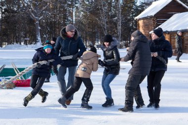 Irkutsk, Rusya - 8 Ocak 2019: Mutlu insanlar Taltci Müzesinde halat çekme oyunu oynarken eğleniyorlar.