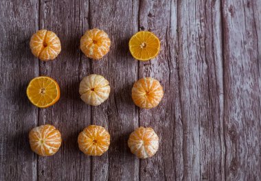 Kahverengi ahşap arka planda dokuz portakal olgunlaşmış mandalina.