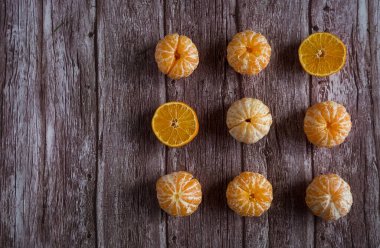 Kahverengi ahşap arka planda turuncu taze mandalina.