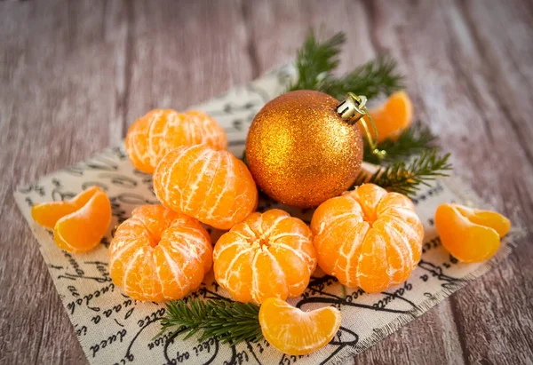 Mandarines orange et boule jouet sur branches sapin de Noël sur fond bois. — Photo
