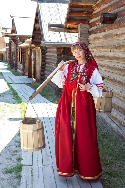 Mooie jonge vrouw in russische authentieke nationale rode kleren met ornament — Stockfoto