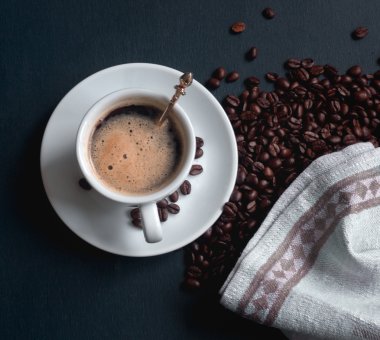 Mavi ahşap zemin üzerine kahve çekirdekleri ile espresso fincan