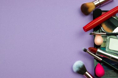 Mor arka planda bir sürü makyaj malzemesi