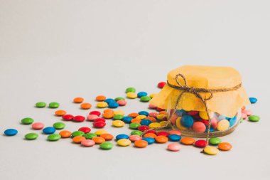 Çikolata şekerler, küçük renkli, fiyonklu bir kavanozda..