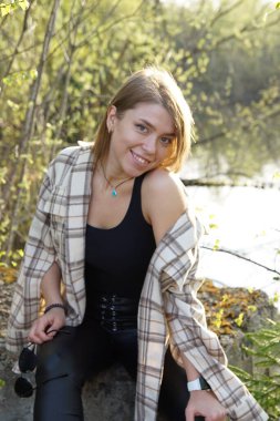 Açık kahverengi saçlı ve kareli gömlekli gülümseyen kız..