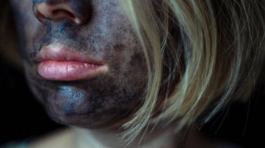 Kadının dudakları ve yüzünde temizleyici bir kömür maskesi.
