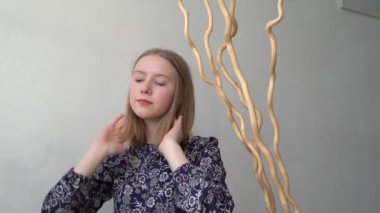 Genç kız dans ediyor ve evinde takılıyor. Rahatlama zamanı. Mükemmel ruh hali. Tek başıma. Gri arka planda mavi gözlü genç kız. Modellik. Pozisyon