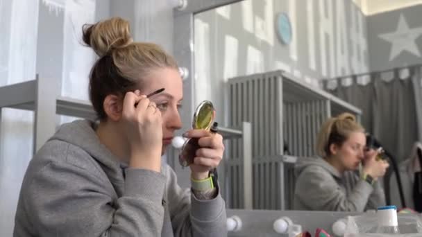 스러운 소녀는 액체로 눈썹을 거울을 얼굴은 깨끗하고 화장도 탈의실에 앉아서 — 비디오