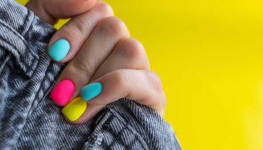 Turuncu, pembe, mavi, sarı renkli parlak tırnaklı avuç içinde siyah kot bulunur.