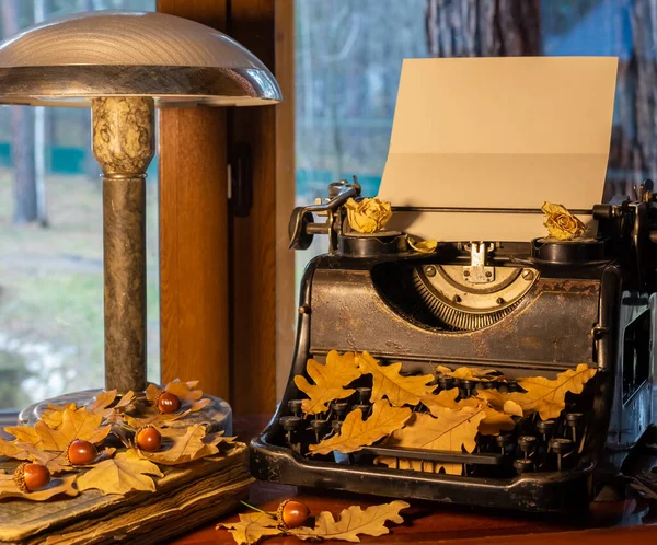 Vintage shabby typewriter, blank paper and fallen oak leaves in autumn — Stock Photo, Image