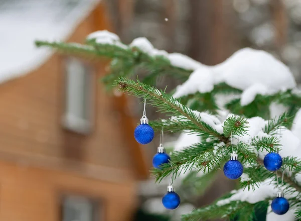 Christmas balls on a spruce branch in the yard of the house — Stock Photo, Image