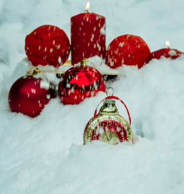 Karda kırmızı mumlar ve noel baloları