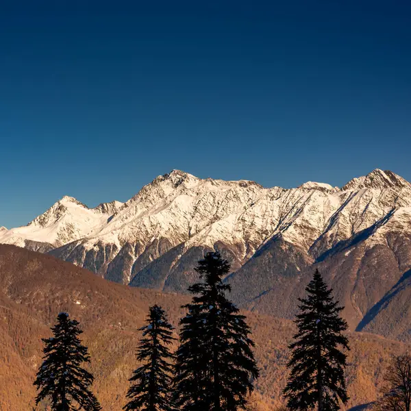 Sonbahar ormanlarından kardaki yüksek dağlara kadar manzara. Sonbahardan kışa geçiş