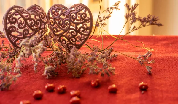 Two hearts and limonium flower on a red tablecloth — Stock Photo, Image