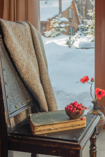 Pencerenin yanındaki eski bir sandalyede eski bir kitap yatıyor. — Stok fotoğraf