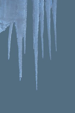 Güneşin altında eriyen buz saçakları ile bahar arkaplanı