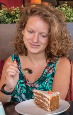 Genç güzel kız kahvaltı yapıyor. Sabah kahvesini içer ve ballı kek yer..