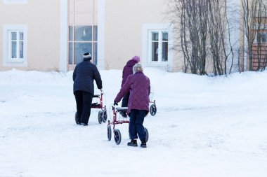Umea, Norrland İsveç - 4 Mart 2021: yaşlı bayanlar aylaklarıyla karda geziyorlar. 