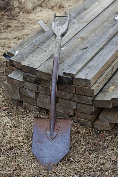 Bir kürek ve bir yığın içinde duran kalaslar. 