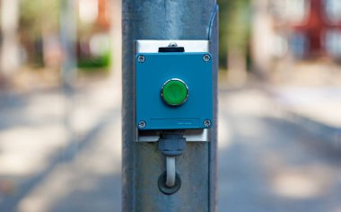 Bir elektrik direğine takılı yeşil bir düğme 