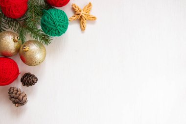 Noel kompozisyonu. Kırmızı ve yeşil iplik yumakları, beyaz arka planda kırmızı kurdeleli hediyeler. Parlak iplik örme konsepti. Düz yatış, üst görünüm.