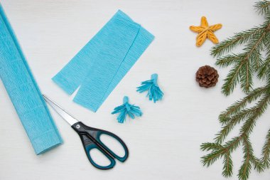 Kağıttan Noel ağacı yapmak. Masadaki makas, mavi kağıt ve köknar dalları. Orijinal bir çocuk sanat projesi. Diy konsepti. Adım adım fotoğraf talimatları. 4. Adım.