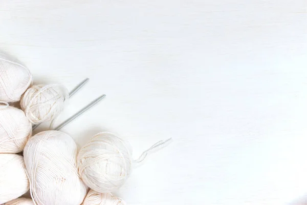 Many skeins of yarn for knitting in white on a light background. Colorless, monochrome, modern style. Women's and men's hobby knitting. Flat lay, top view.