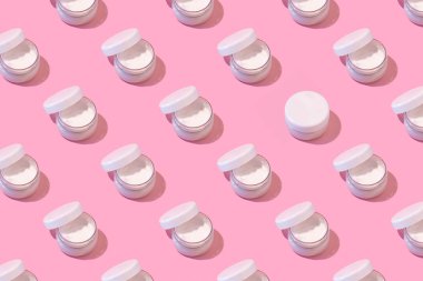 Pastel pembe arka planda açık krema kalıpları. En düşük cilt bakımı konsepti.