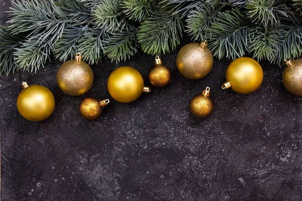 Schöne Goldene Weihnachtskugeln Und Ein Tannenzweig Auf Dunkelschwarzem Hintergrund Flaches — Stockfoto