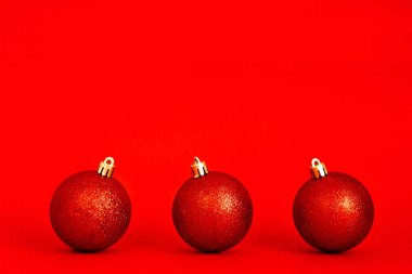 Kırmızı arka planda kırmızı parlak Noel topları. Yeni yıl ve Noel konsepti. Minimum festival kompozisyonu. metin için boşluk kopyala.