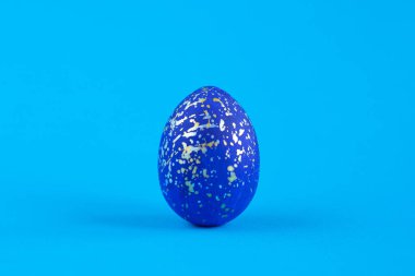 İsa dirildi. Paskalya yumurtası altın ve gümüş boya ile maviye boyanmış..