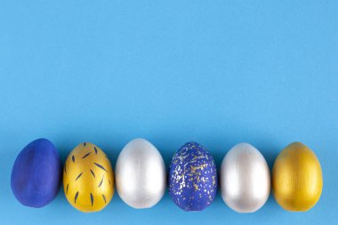 İsa dirildi. Paskalya yumurtalarının gümüş, altın ve mavi yazılı metni için çerçeve.