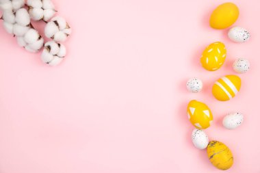 Mutlu Paskalyalar. Yumurtalar pembe renkli arka planda sarıdır. Düz konum, üst görünüm, kopyalama alanı.