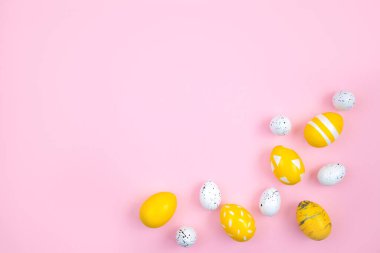 Mutlu Paskalyalar. Yumurtalar pembe renkli arka planda sarıdır. Düz konum, üst görünüm, kopyalama alanı.