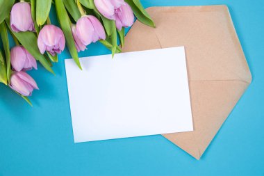 Mavi arka planda laleler. Temiz metin alanı olan şenlikli çiçek konsepti. Düz yatıyordu. Yukarıdan görüntüle.