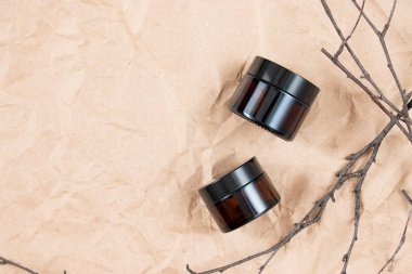 Buruşmuş el işi kağıdının üzerindeki kehribar camından yapılmış komik şişeler. Cilt bakım ürünleri ambalaj tasarımı. Spa konsepti.