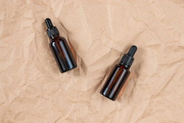 Buruşmuş el işi kağıdının üzerindeki kehribar camından yapılmış komik şişeler. Cilt bakım ürünleri ambalaj tasarımı. Spa konsepti.