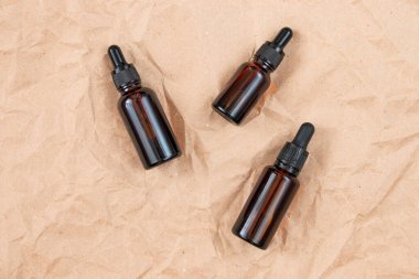 Buruşmuş el işi kağıdının üzerindeki kehribar camından yapılmış komik şişeler. Cilt bakım ürünleri ambalaj tasarımı. Spa konsepti.