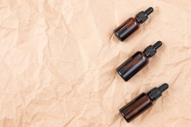 Buruşmuş el işi kağıdının üzerindeki kehribar camından yapılmış komik şişeler. Cilt bakım ürünleri ambalaj tasarımı. Spa konsepti.