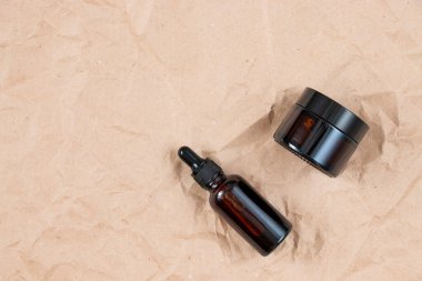 Buruşmuş el işi kağıdının üzerindeki kehribar camından yapılmış komik şişeler. Cilt bakım ürünleri ambalaj tasarımı. Spa konsepti.