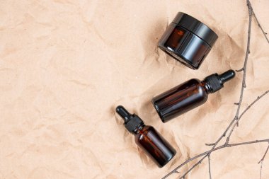 Buruşmuş el işi kağıdının üzerindeki kehribar camından yapılmış komik şişeler. Cilt bakım ürünleri ambalaj tasarımı. Spa konsepti.