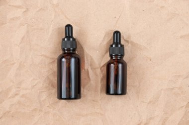 Buruşmuş el işi kağıdının üzerindeki kehribar camından yapılmış komik şişeler. Cilt bakım ürünleri ambalaj tasarımı. Spa konsepti.