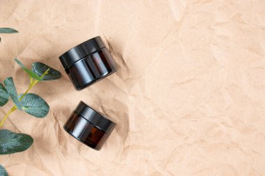 Buruşmuş el işi kağıdının üzerindeki kehribar camından yapılmış komik şişeler. Cilt bakım ürünleri ambalaj tasarımı. Spa konsepti.