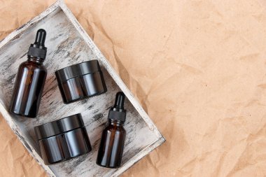 Buruşmuş el işi kağıdının üzerindeki kehribar camından yapılmış komik şişeler. Cilt bakım ürünleri ambalaj tasarımı. Spa konsepti.