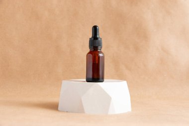 Beton bir podyumda kehribar cam kozmetik şişeleriyle Kraft kağıdının arka planına karşı yaratıcı bir yaşam. Spa ve cilt bakımı kavramı.