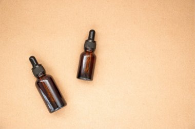 Bej renkli pastel arka planda iki kehribar cam şişe. Doğal organik eko-kozmetik. Güzellik salonu modelleme. Aromaterapi.